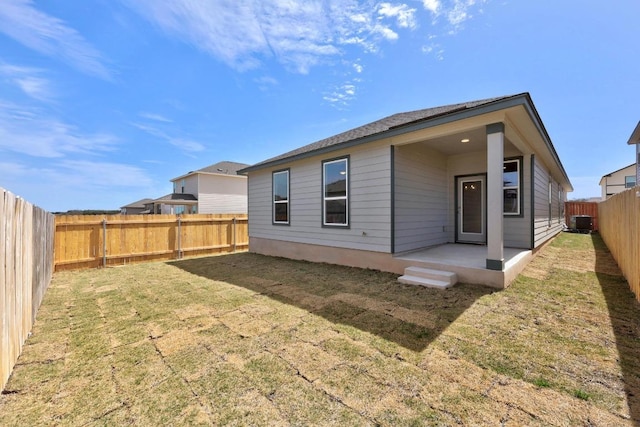 rear view of property with a yard, cooling unit, a fenced backyard, and a patio