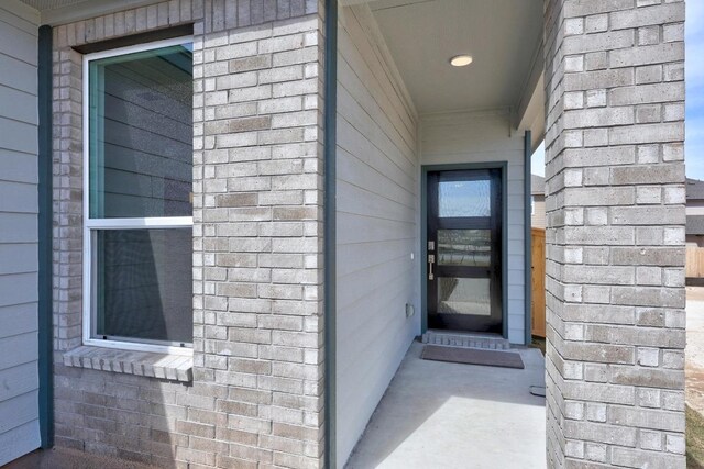 doorway to property with brick siding