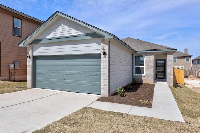 view of front of property featuring a shingled roof, concrete driveway, brick siding, and an attached garage