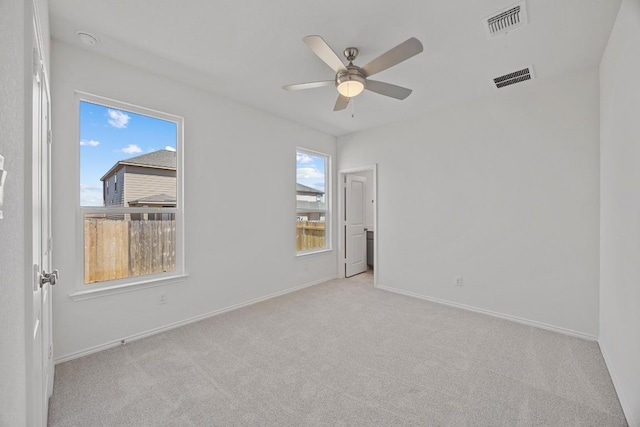 empty room featuring baseboards, carpet, visible vents, and a ceiling fan