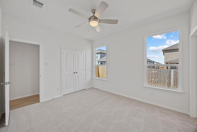 unfurnished bedroom with baseboards, a closet, visible vents, and carpet flooring