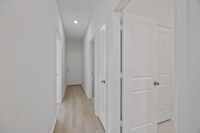 hallway featuring light wood-type flooring and baseboards