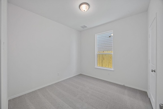 empty room featuring carpet, visible vents, and baseboards