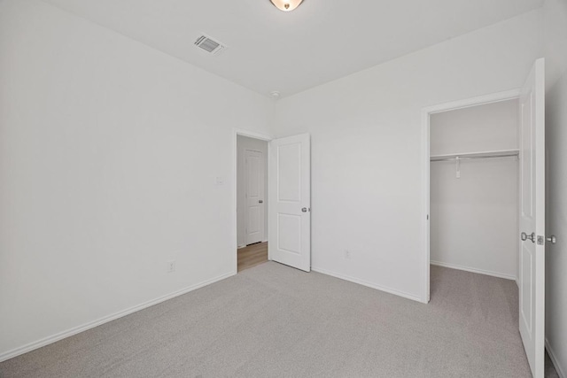 unfurnished bedroom featuring carpet floors, visible vents, baseboards, and a closet