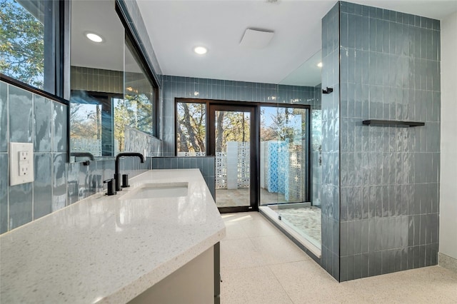 bathroom featuring vanity and tile walls