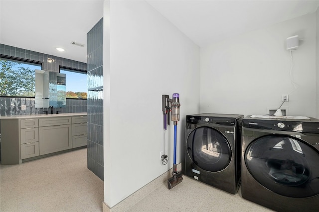 washroom with separate washer and dryer and sink