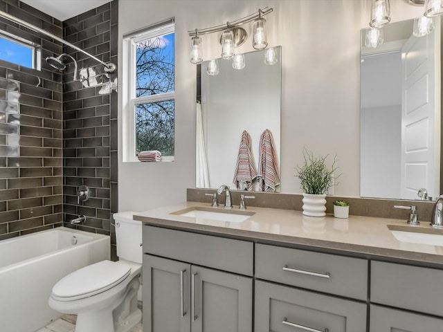 full bathroom with toilet, vanity, tiled shower / bath combo, and a healthy amount of sunlight