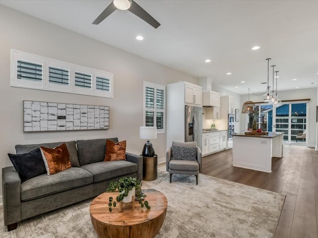 living room featuring ceiling fan and dark wood-type flooring