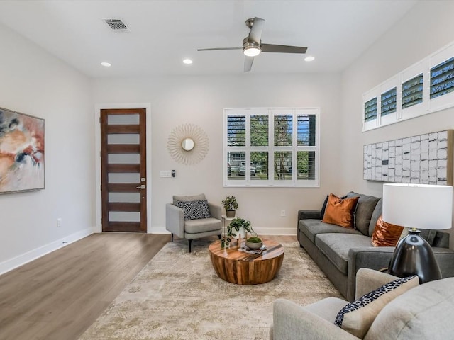 living room featuring ceiling fan and light hardwood / wood-style flooring