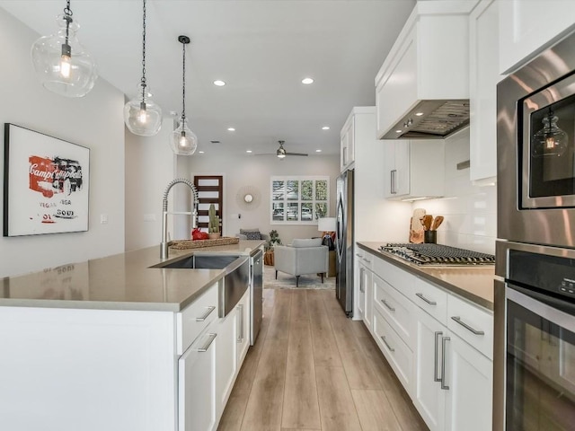 kitchen with white cabinets, pendant lighting, stainless steel appliances, and custom exhaust hood