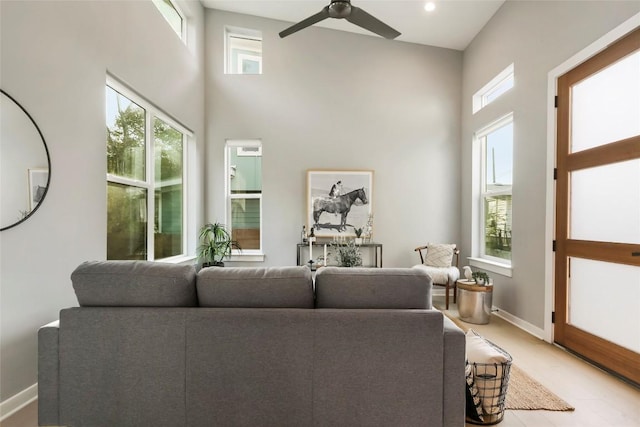 living room featuring ceiling fan and a towering ceiling