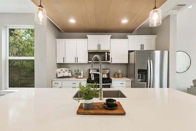 kitchen featuring appliances with stainless steel finishes, backsplash, pendant lighting, wooden ceiling, and white cabinetry