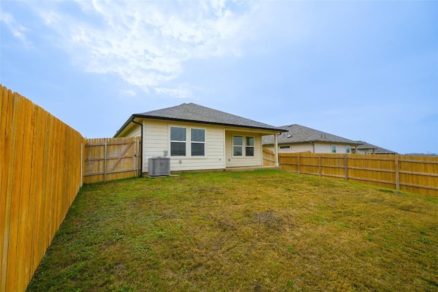 back of house featuring central AC and a yard