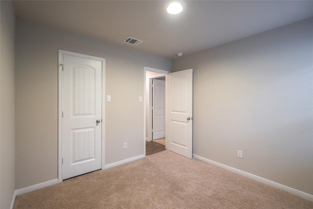 unfurnished bedroom featuring light carpet