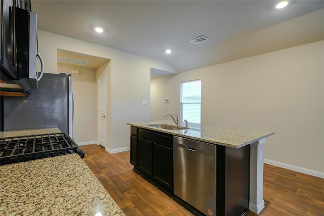 kitchen with light stone counters, sink, an island with sink, and appliances with stainless steel finishes