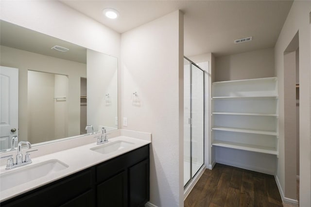 bathroom with a shower with door, vanity, and wood-type flooring