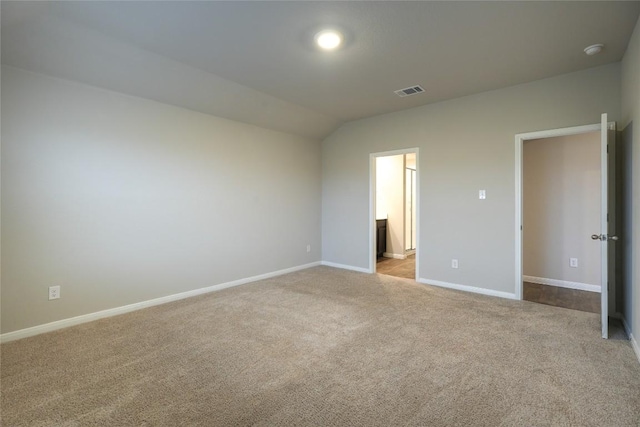 unfurnished bedroom with ensuite bathroom, lofted ceiling, and light carpet