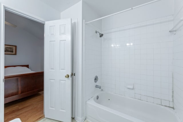 bathroom with hardwood / wood-style flooring and shower / tub combination