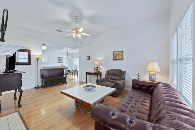 living room featuring light wood-type flooring and ceiling fan with notable chandelier