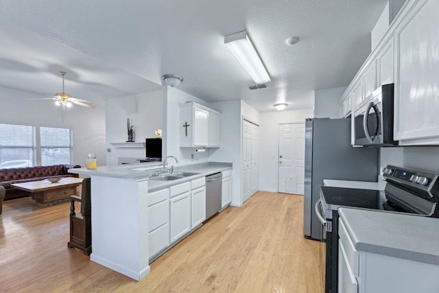 kitchen featuring white cabinetry, sink, stainless steel appliances, and a textured ceiling