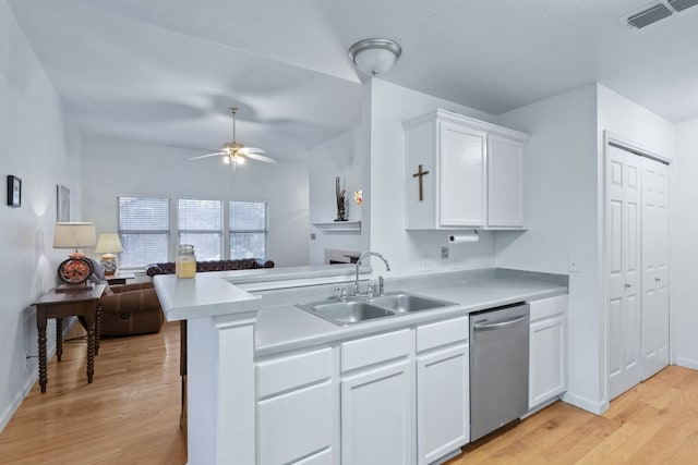 kitchen with kitchen peninsula, sink, stainless steel dishwasher, light wood-type flooring, and white cabinetry