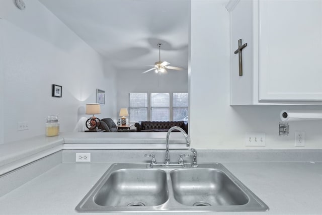 kitchen with white cabinets, ceiling fan, and sink