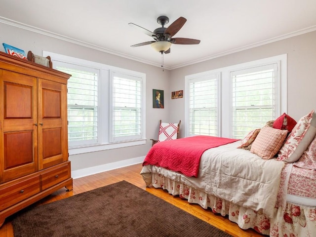 bedroom with multiple windows, light wood-type flooring, ceiling fan, and crown molding