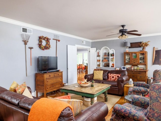 living room with ceiling fan and crown molding