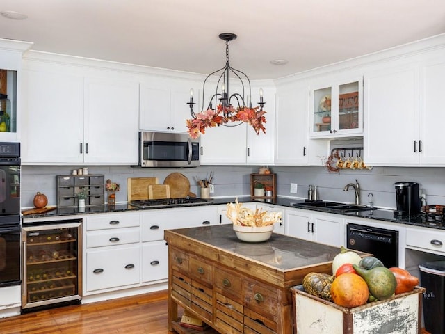 kitchen featuring black appliances, sink, decorative backsplash, decorative light fixtures, and beverage cooler