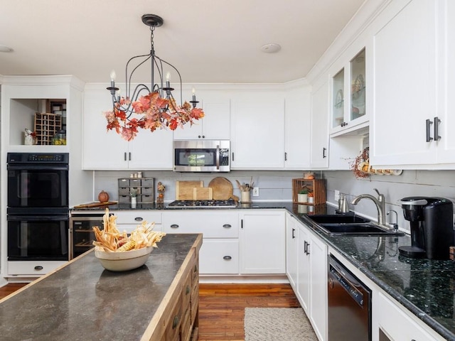 kitchen featuring black appliances, white cabinetry, sink, and hanging light fixtures