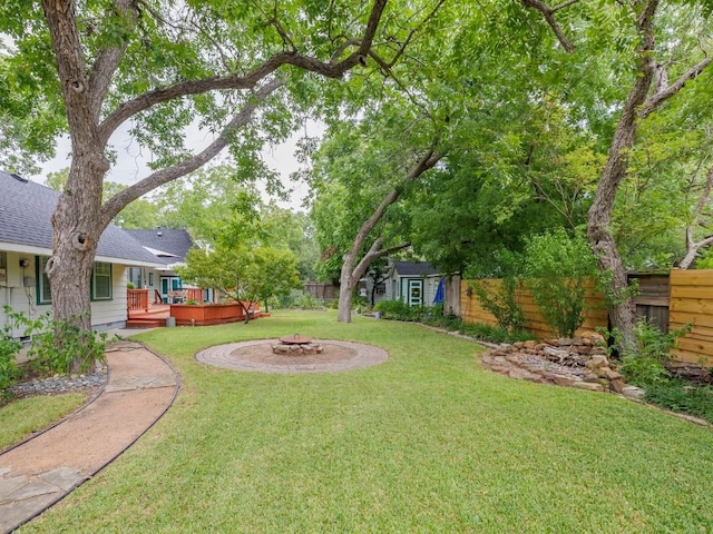 view of yard with a deck and an outdoor fire pit