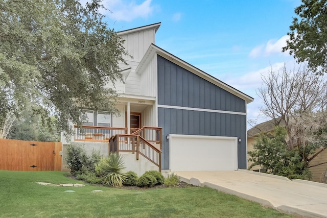 view of front of house with a front yard, a garage, and covered porch