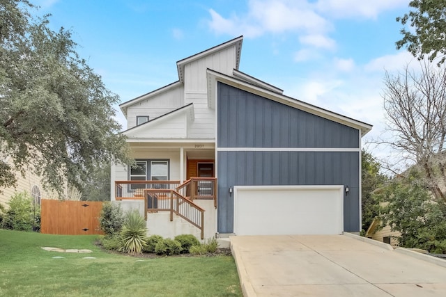 view of front facade with covered porch, a garage, and a front yard