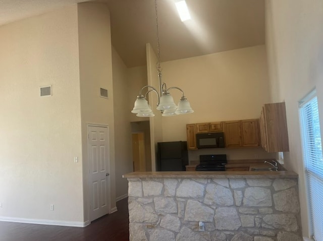 kitchen with high vaulted ceiling, an inviting chandelier, black appliances, dark hardwood / wood-style floors, and kitchen peninsula