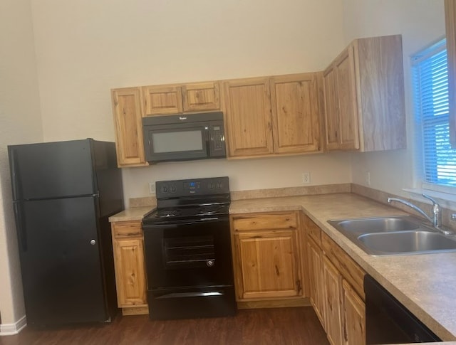 kitchen featuring dark wood-type flooring, black appliances, sink, a wealth of natural light, and light brown cabinetry