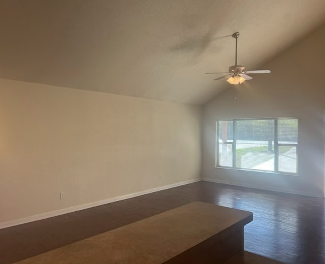 spare room with vaulted ceiling, ceiling fan, and dark wood-type flooring