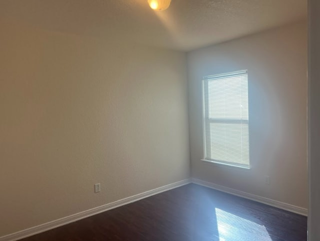 unfurnished room featuring dark hardwood / wood-style flooring