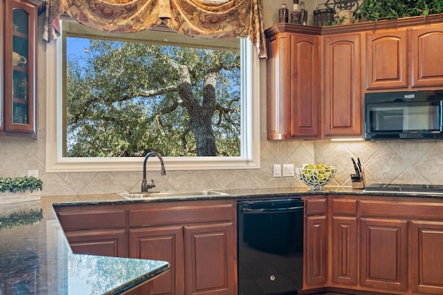 kitchen with sink, dark stone counters, and black appliances