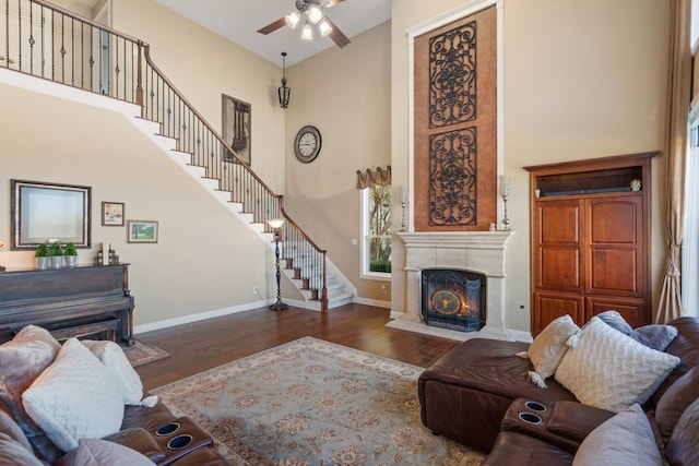 living room featuring ceiling fan, dark hardwood / wood-style flooring, and a high ceiling