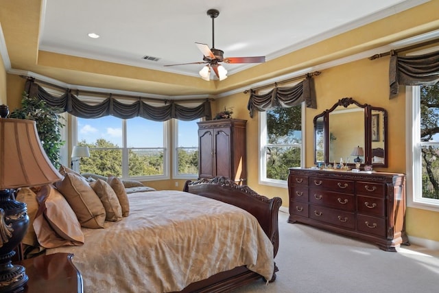 carpeted bedroom featuring ceiling fan, a raised ceiling, and crown molding