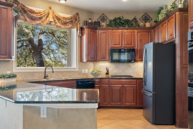 kitchen with black appliances, light tile patterned flooring, kitchen peninsula, and sink