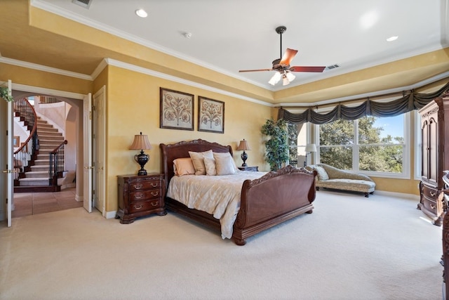 bedroom featuring ceiling fan, carpet floors, ornamental molding, and a tray ceiling