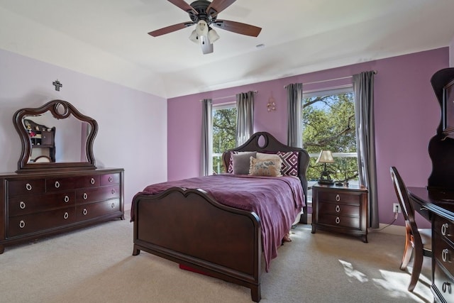 bedroom featuring ceiling fan, light colored carpet, and vaulted ceiling