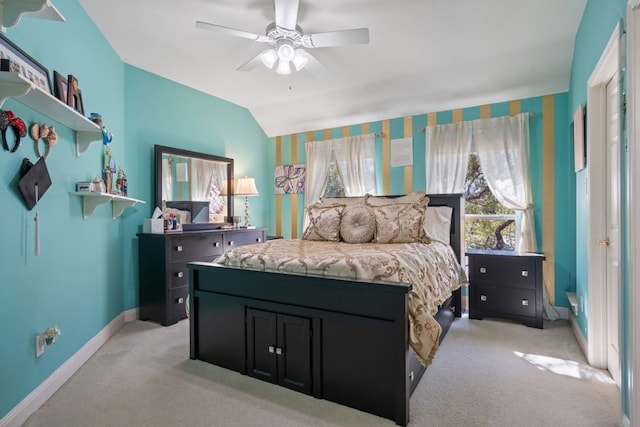 carpeted bedroom with ceiling fan and vaulted ceiling