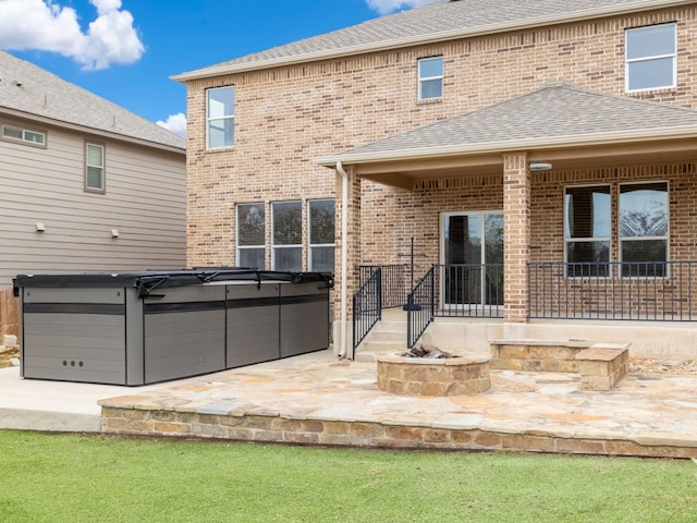 rear view of property with a patio and a hot tub