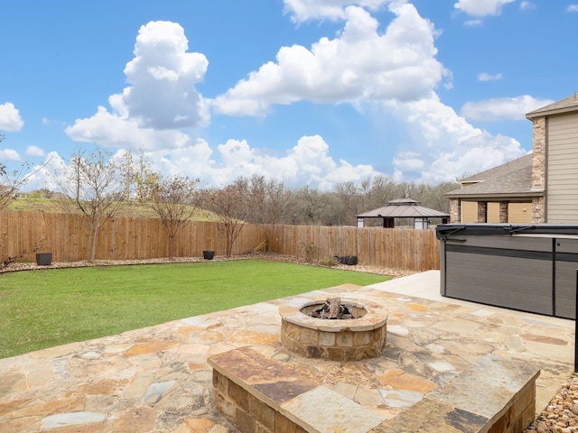 view of patio with a hot tub and a fire pit