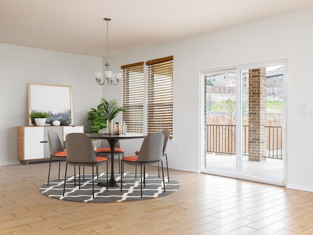 dining area with light hardwood / wood-style floors and a chandelier