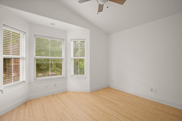 empty room featuring light hardwood / wood-style floors, vaulted ceiling, ceiling fan, and a healthy amount of sunlight