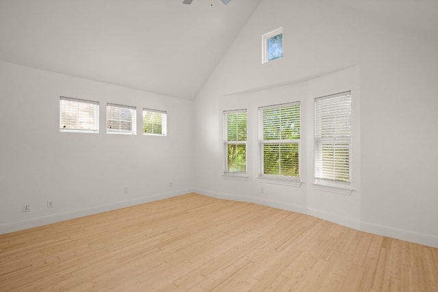 spare room featuring plenty of natural light, ceiling fan, high vaulted ceiling, and light hardwood / wood-style flooring