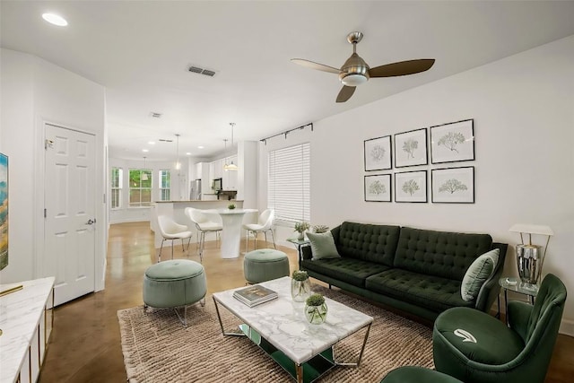 living room with ceiling fan and concrete flooring